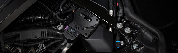 Unidad de control RaceChip GTS 5 instalada en el compartimento del motor con el conector de serie enchufado.