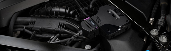 Unidad de control RaceChip GTS 5 Black instalada en el compartimento del motor con el conector de serie enchufado.