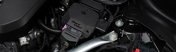 Unidad de control RaceChip RS instalada en el compartimento del motor con el conector de serie enchufado.